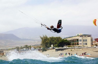  男孩在波涛汹涌的大海中练习风筝冲浪 